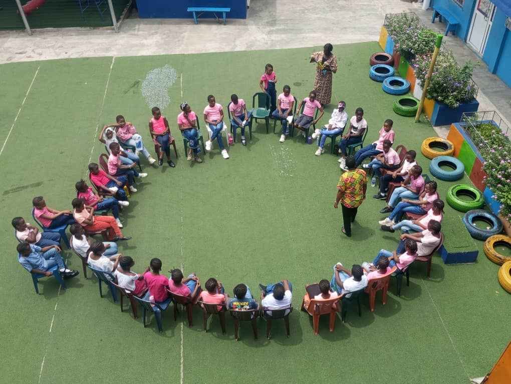 Pupils in a circle game on the courtyard lawn